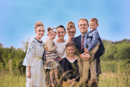 mother and father with five children standing in a field