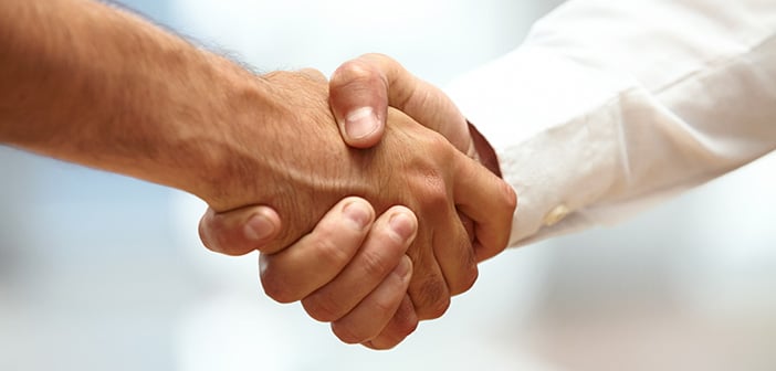 closeup of two men shaking hands indicating partnership