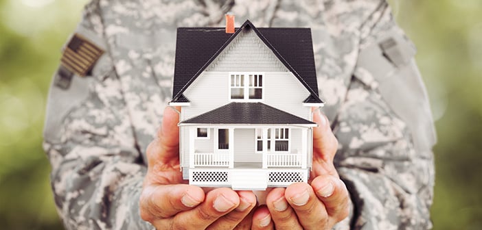 military service member holding model home in hands