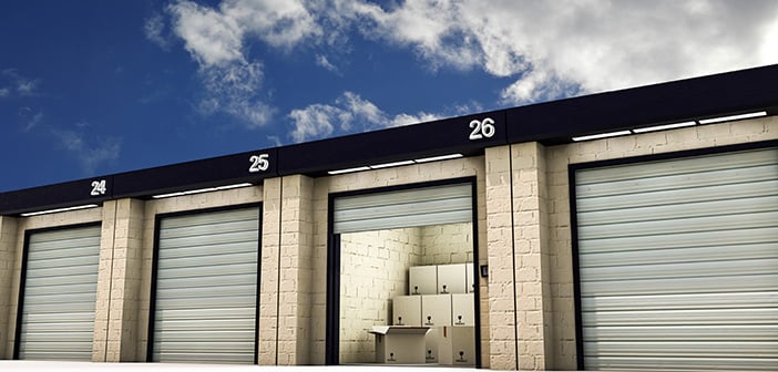 self-storage facility with garage door open and packed boxes stacked inside