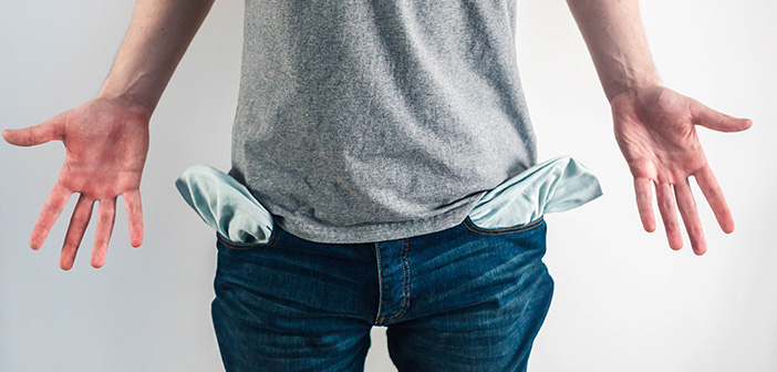 male showing empty pockets implying moneyless