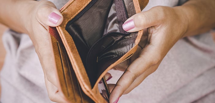 woman holding wallet open showing no money