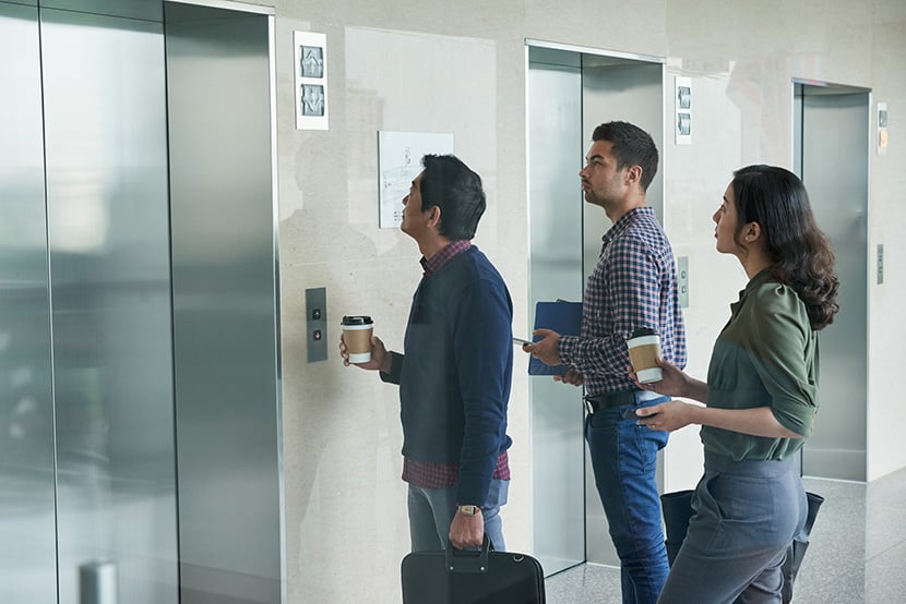 Business people waiting for elevator in office hall