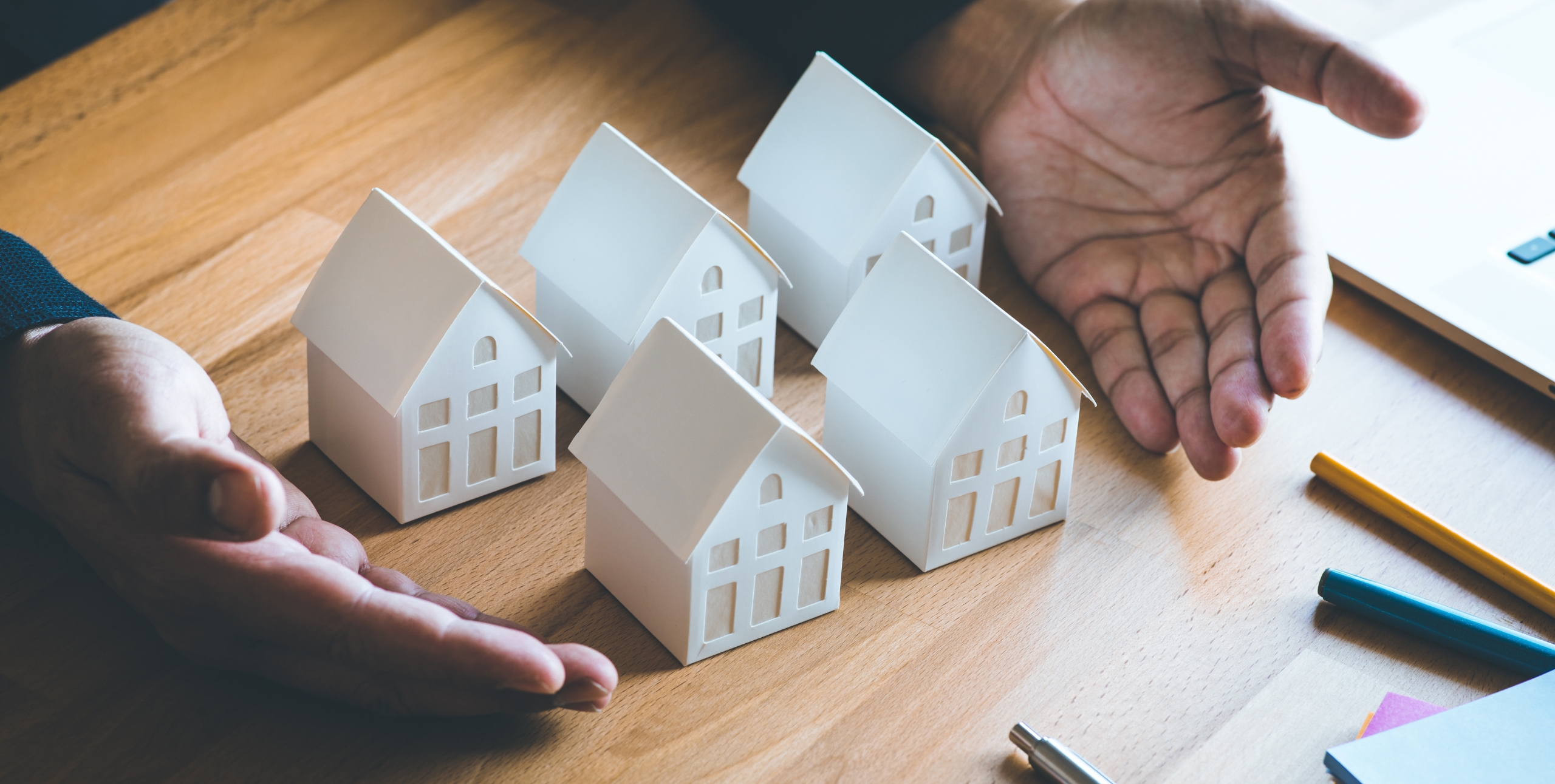 five small houses with hands around them