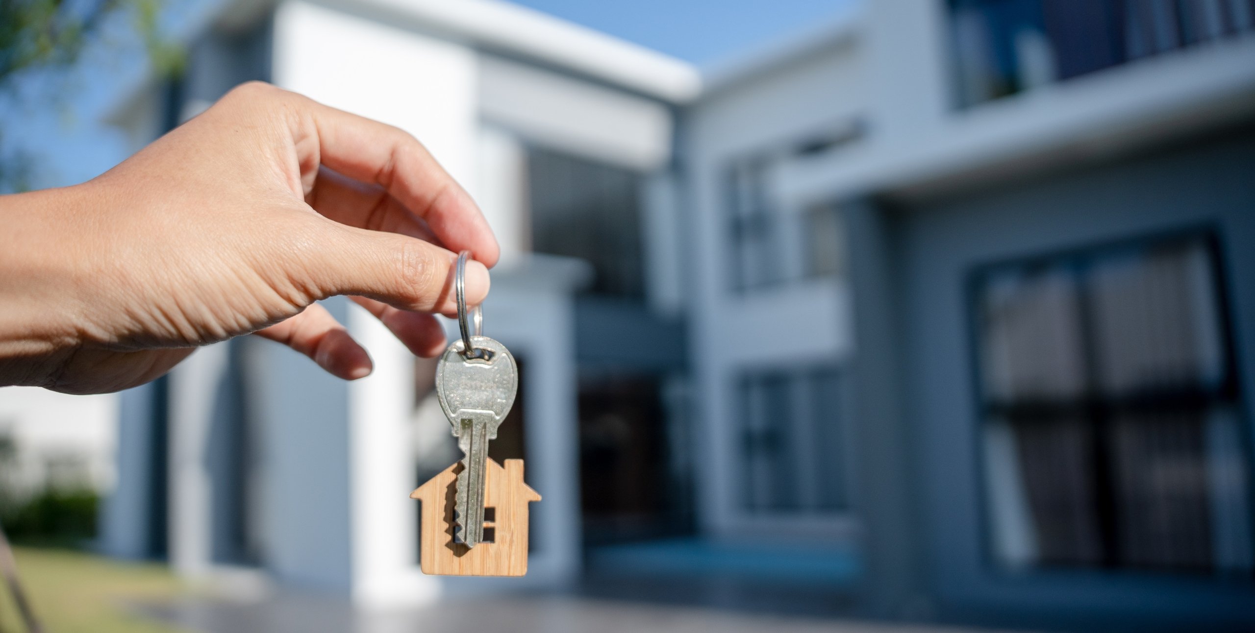 holding keys in front of a house