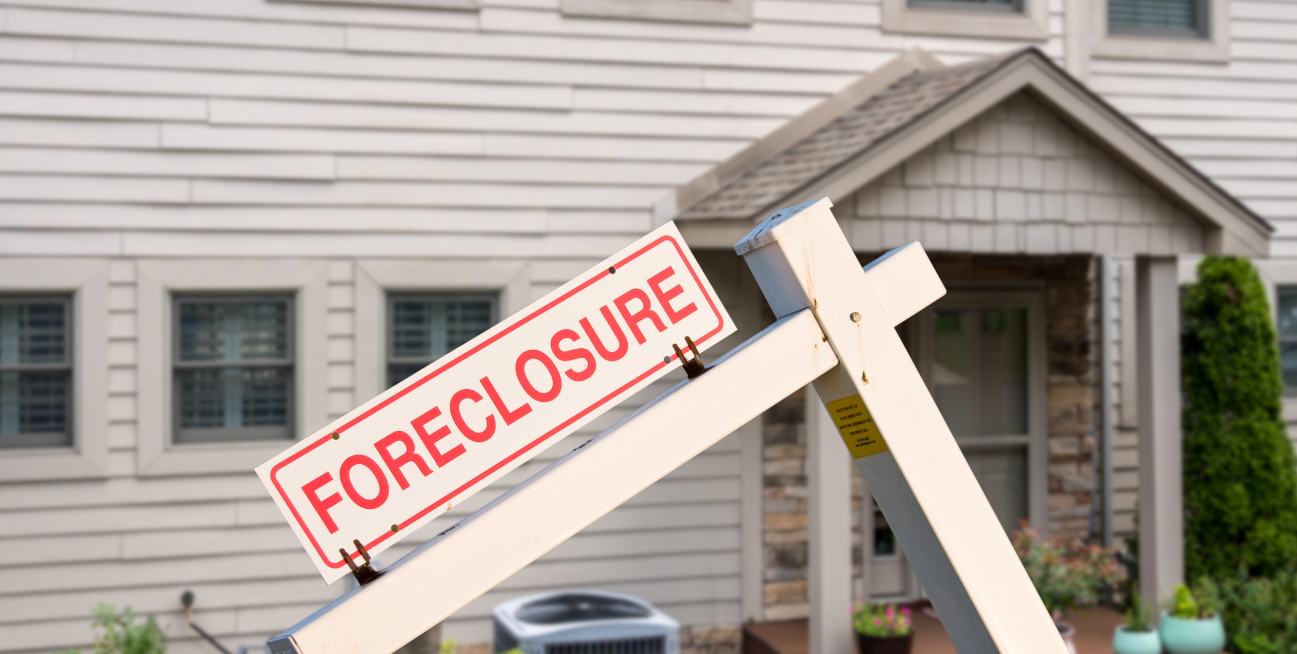 foreclosure sign in front of house