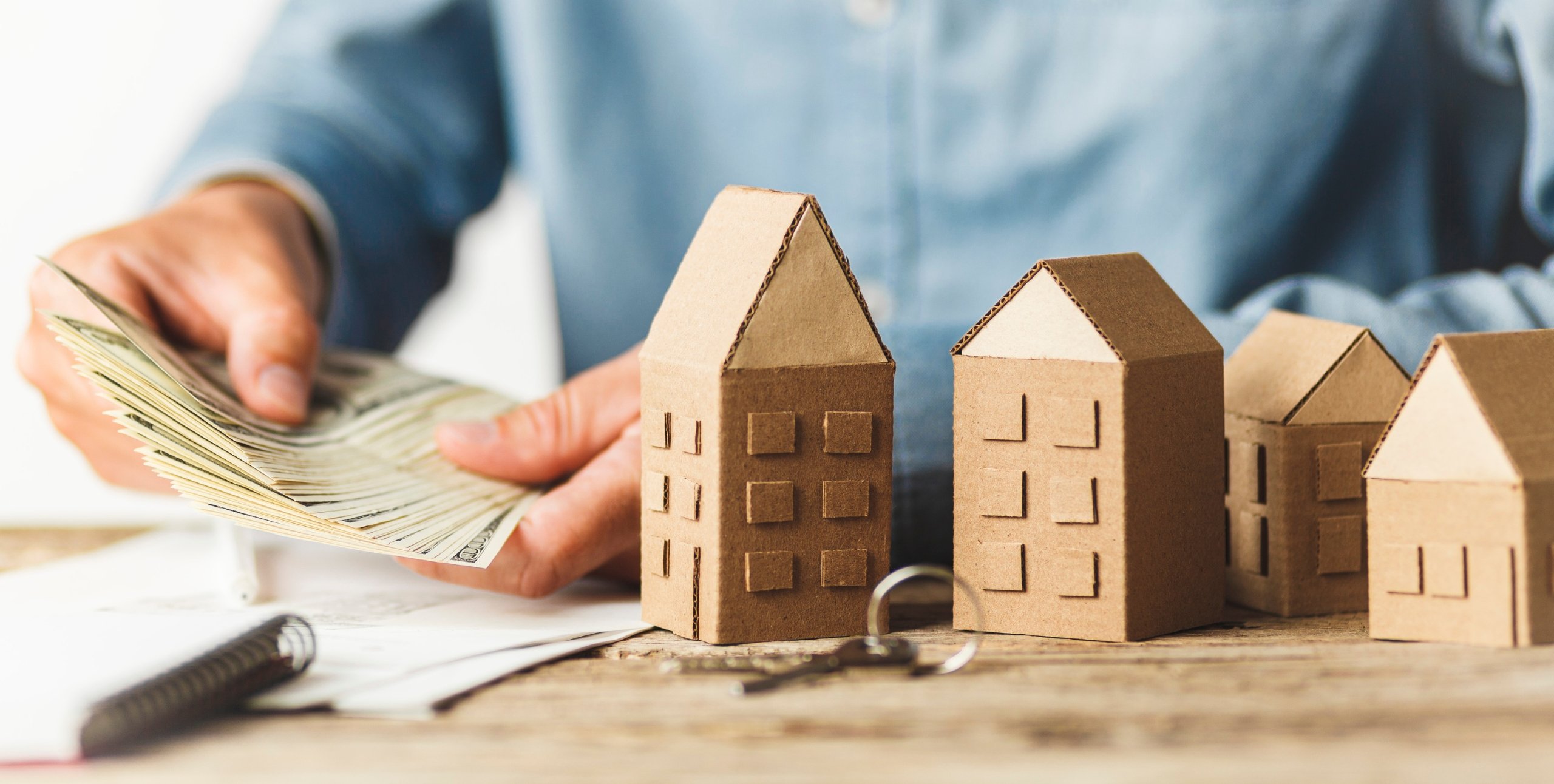 counting cash next to houses