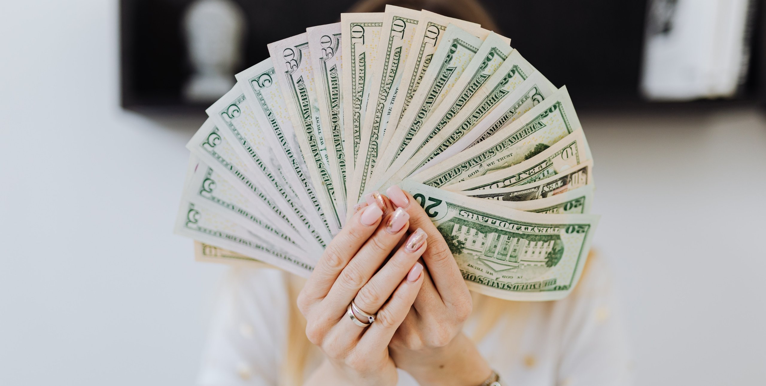 woman holding a wad of cash