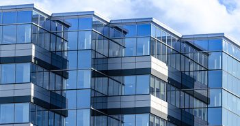 What’s the Best Type of Commercial Real Estate Property for Investors? mirrored glass office building set against cloudy sky